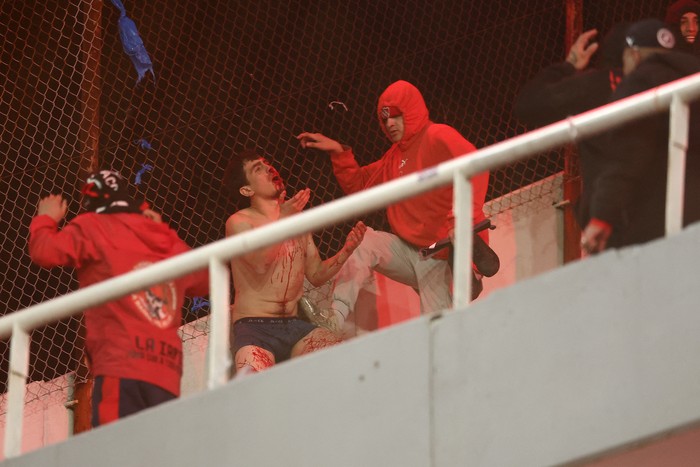 Un hincha de Universidad de Chile tras ser golpeado por hinchas de Independiente, el 20 de agosto, en el estadio Libertadores de América, en Avellaneda, Buenos Aires. · Foto: Alejandro Pagni, AFP Un hincha de Universidad de Chile tras ser golpeado por hinchas de Independiente, el 20 de agosto, en el estadio Libertadores de América, en Avellaneda, Buenos Aires. · Foto: Alejandro Pagni, AFP