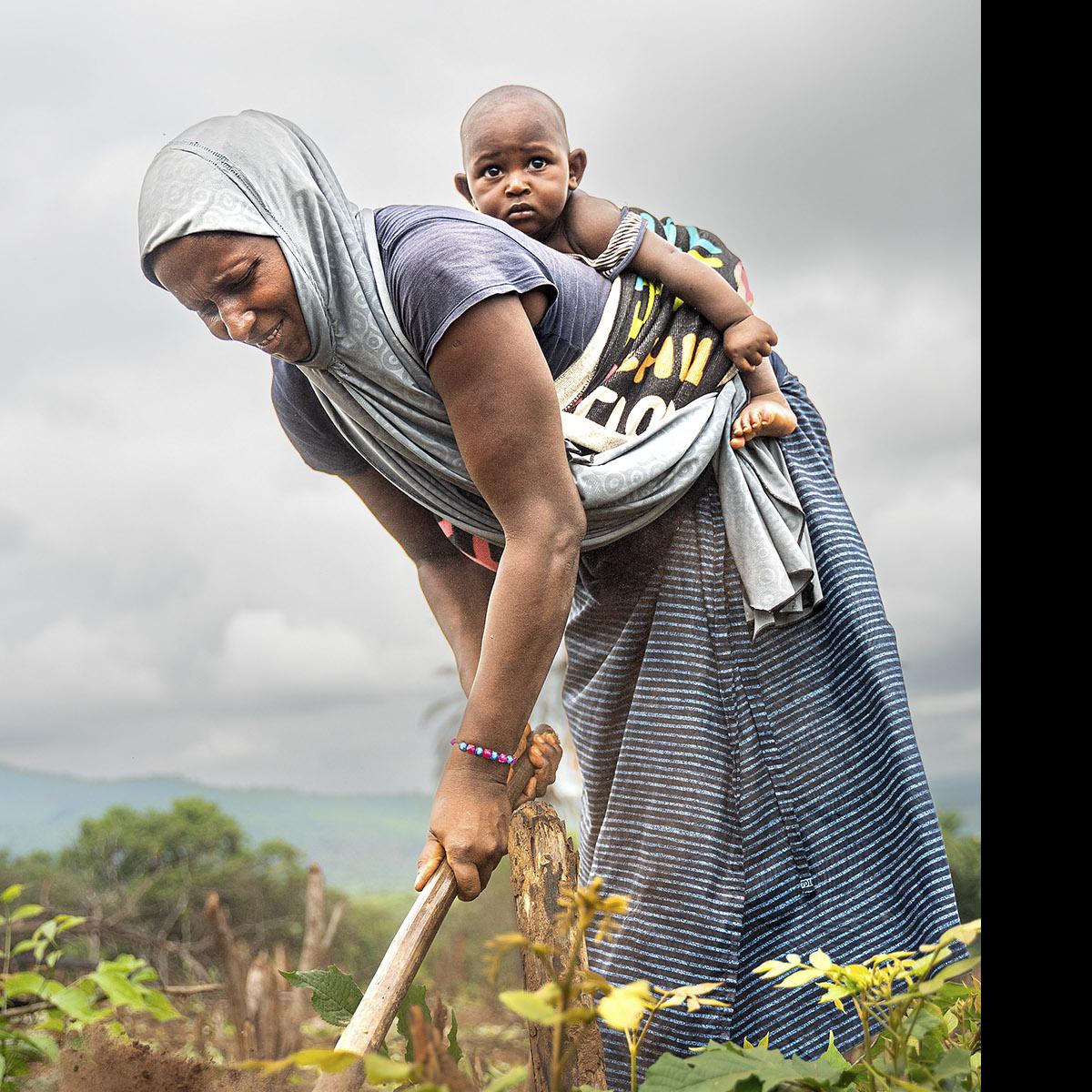 Aissatou con su hijo más pequeño en la huerta familiar. · Foto: Franca Levin