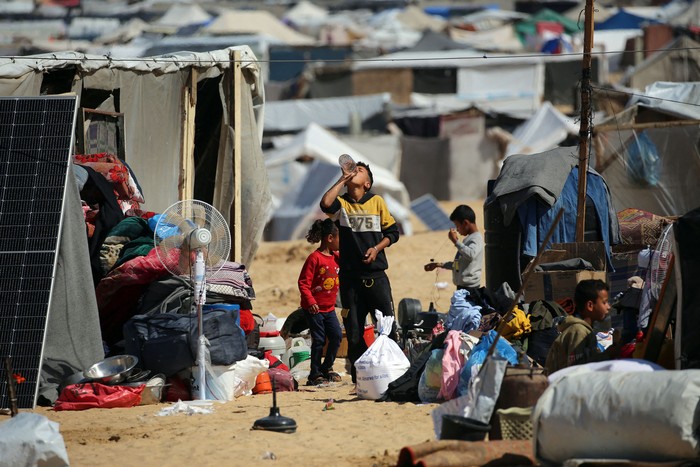 Palestinos desplazados recogen sus pertenencias antes de huir de al-Mawasi a una zona más segura, el 9 de mayo, en Rafah, Franja de Gaza. · Foto: AFP